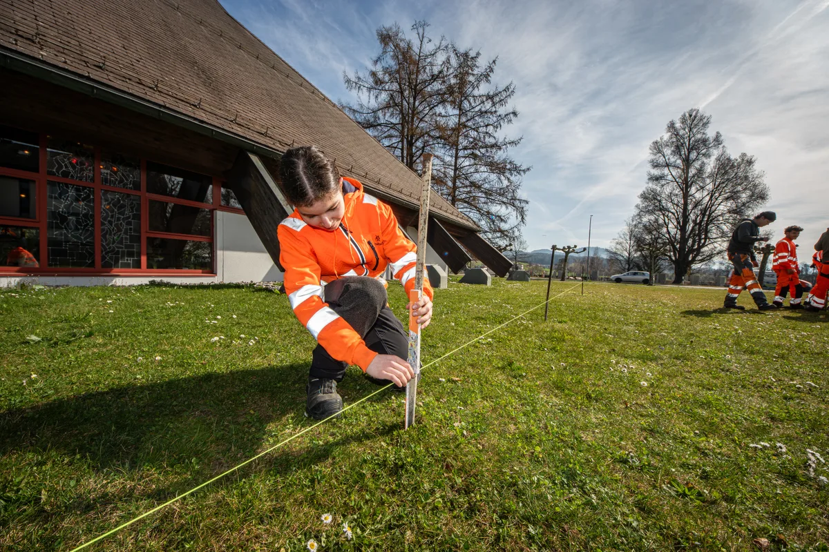 Marisa lernt die wichtigsten Tipps und Tricks beim Abstecken einer Geraden. Marisa W. aus Dübendorf beim Ausmessen.